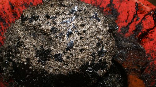 A large black mass in a red container