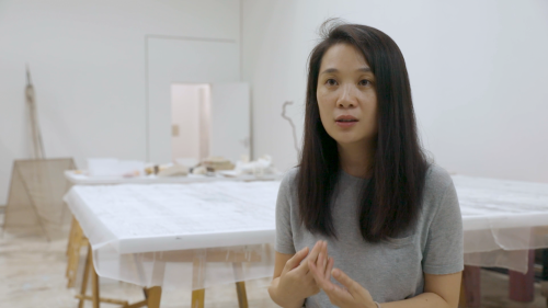 Hu Xiaoyuan seated in her studio