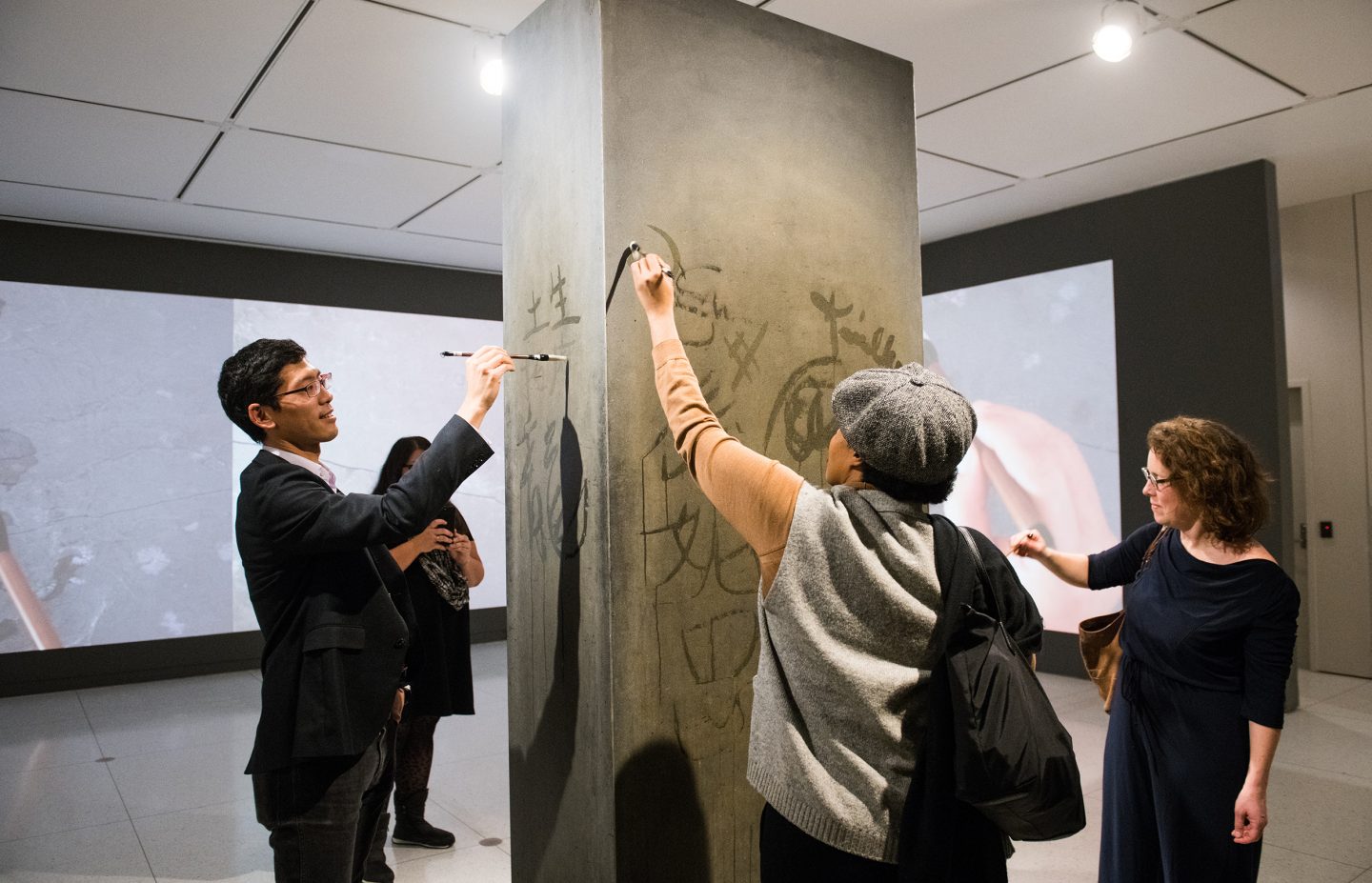 Visitors to the Smart Museum use water and brushes to write on Song Dong's Traceless Stele.